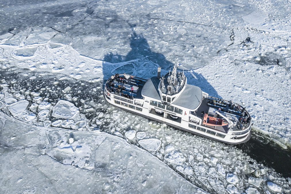 Suomenlinnan lautta ylhäältä päin kuvattuna jään keskellä.